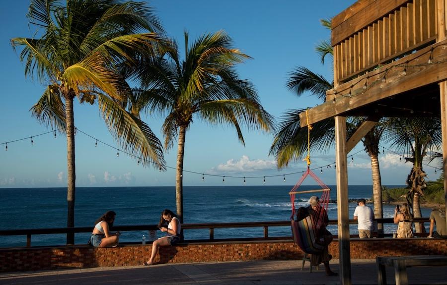 People sitting in bench looking the ocean